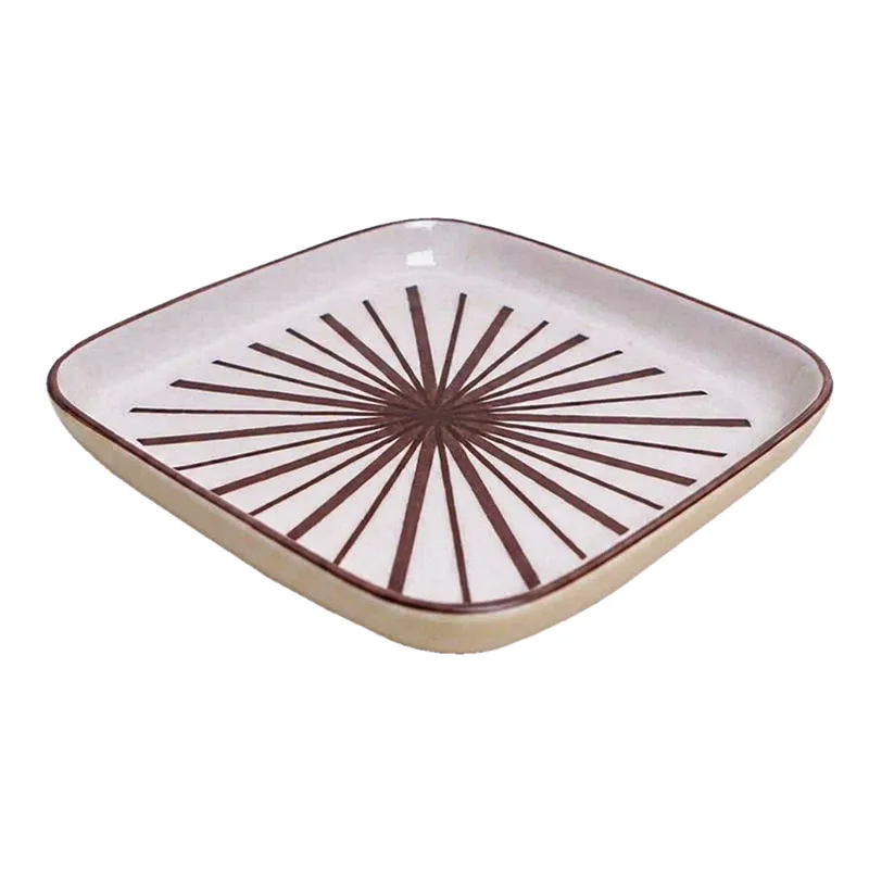 Single square white snack plate with maroon starburst design on a white background