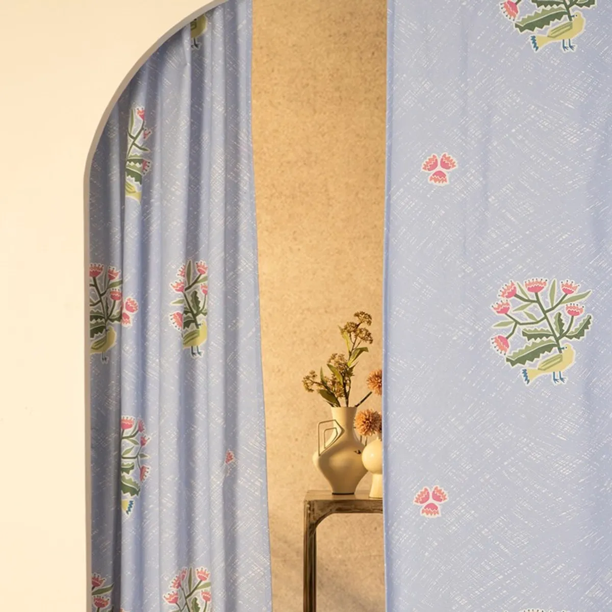 Light blue floral curtains shown beside an arched doorway