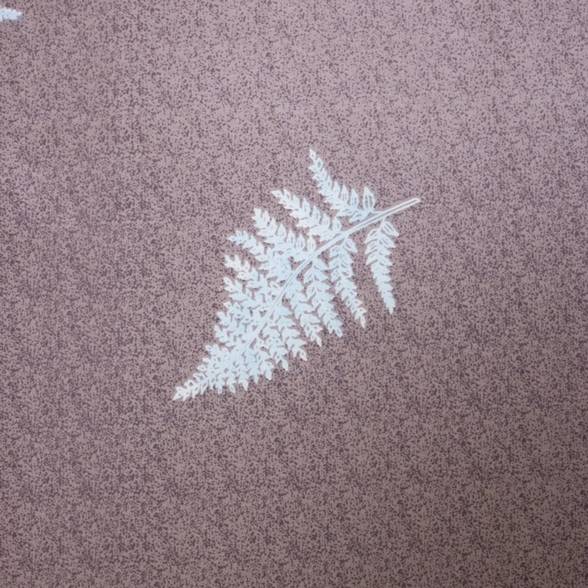 Close-up of a white botanical motif on a purple textured-looking printed fabric