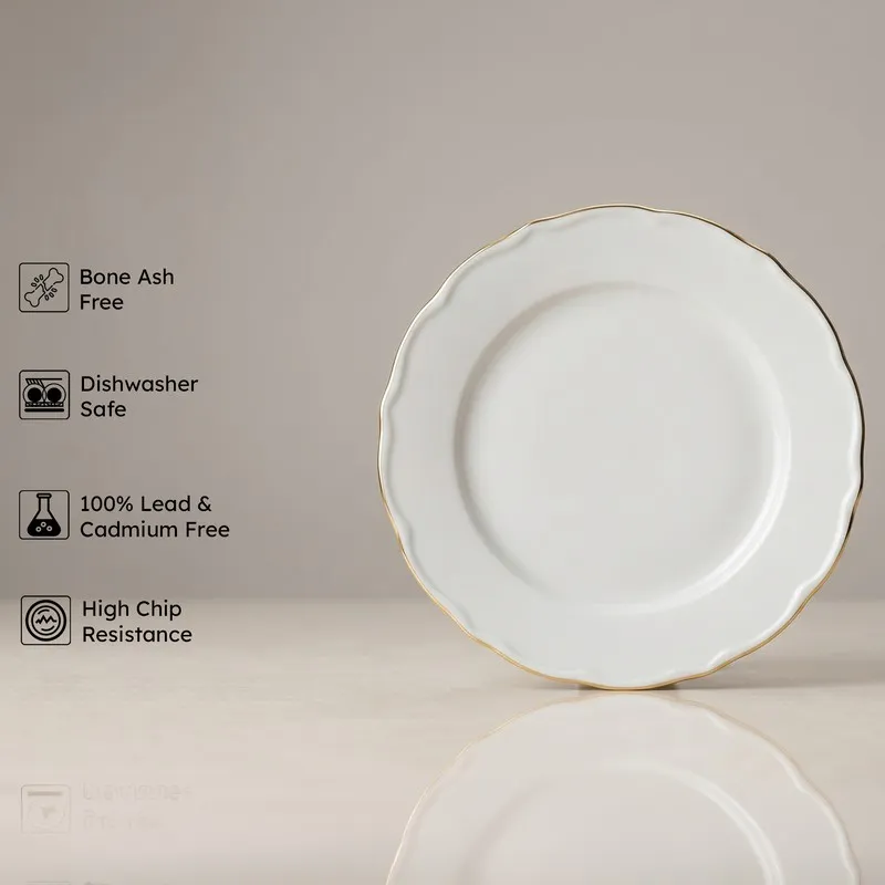 White dinner plate with gold rim shown front on a neutral background