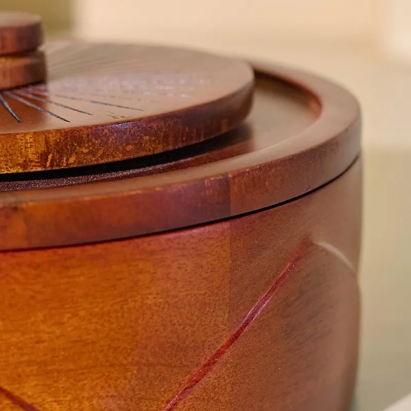 Close-up view of the glossy brown wood rim and lid construction