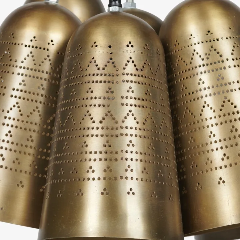 Close-up of gold metal lamp shades with perforated geometric motif