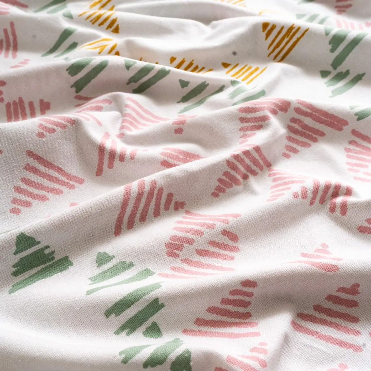 Close-up of soft white curtain fabric with pink and green motifs
