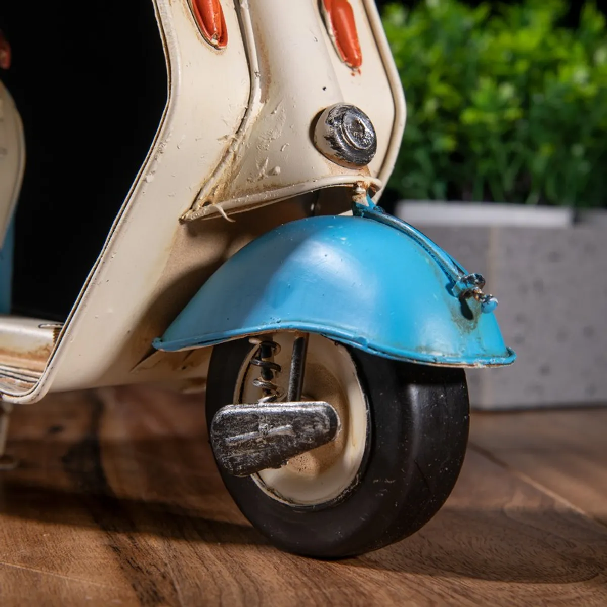 Close-up of the front wheel and blue fender of the scooter showpiece