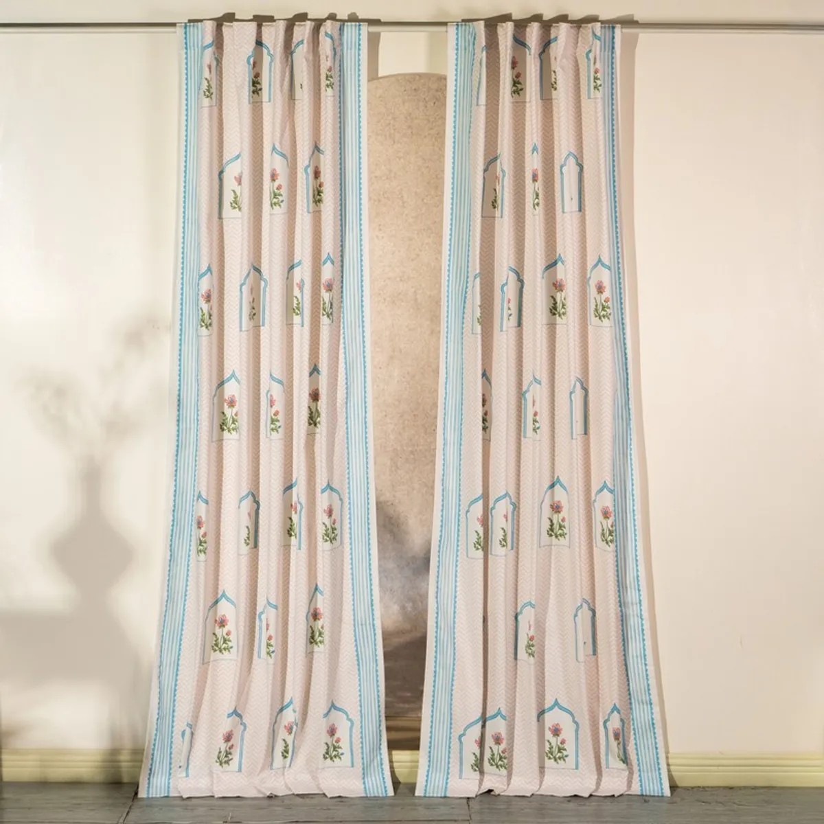 Pair of pink and blue patterned curtains on a rod