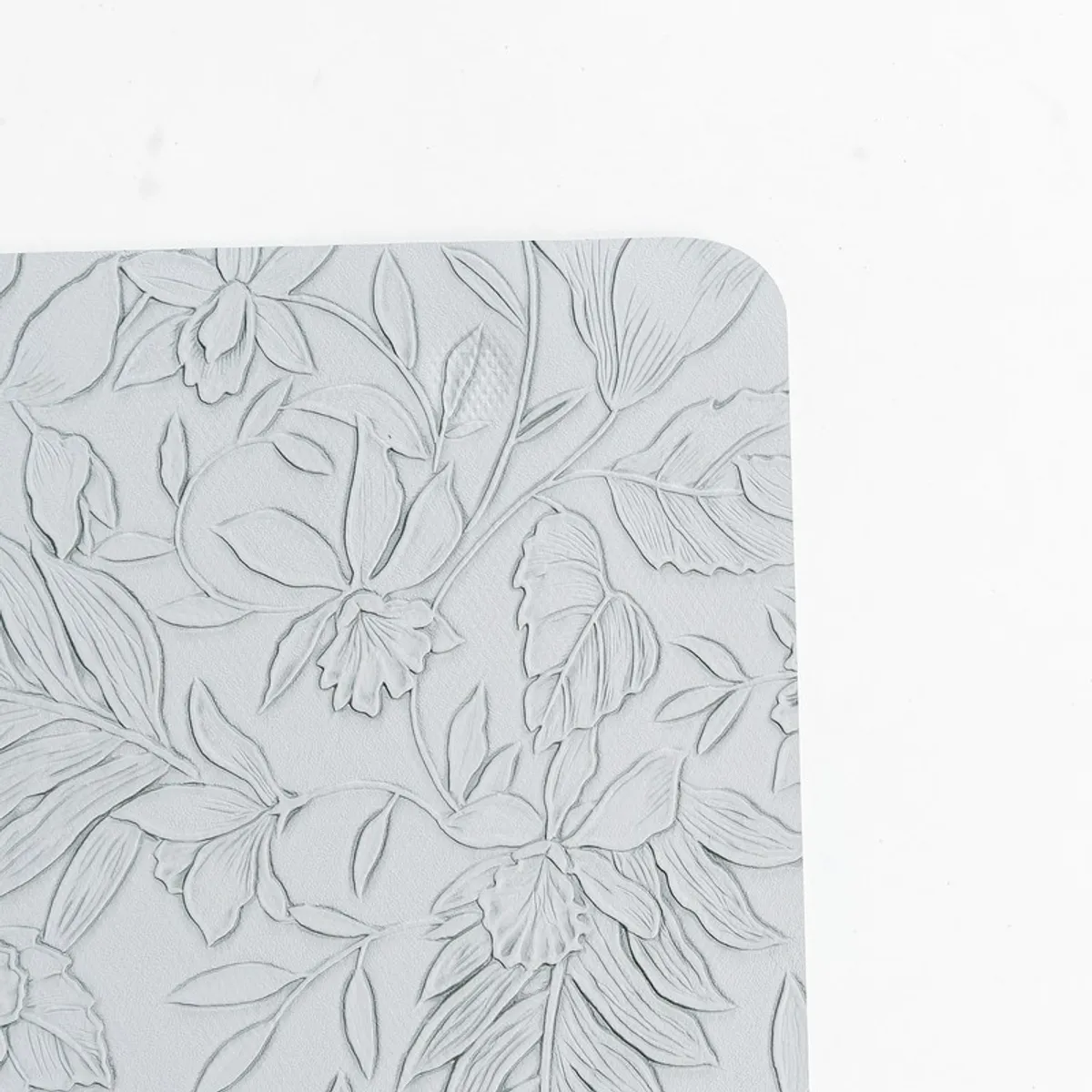 Close-up of grey table mat with embossed floral pattern