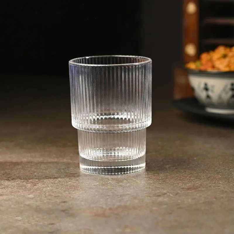 Single clear ribbed cocktail glass on a tabletop