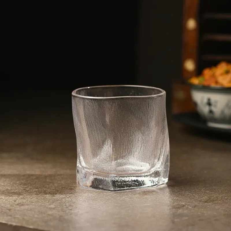 Single clear textured whiskey glass on a tabletop