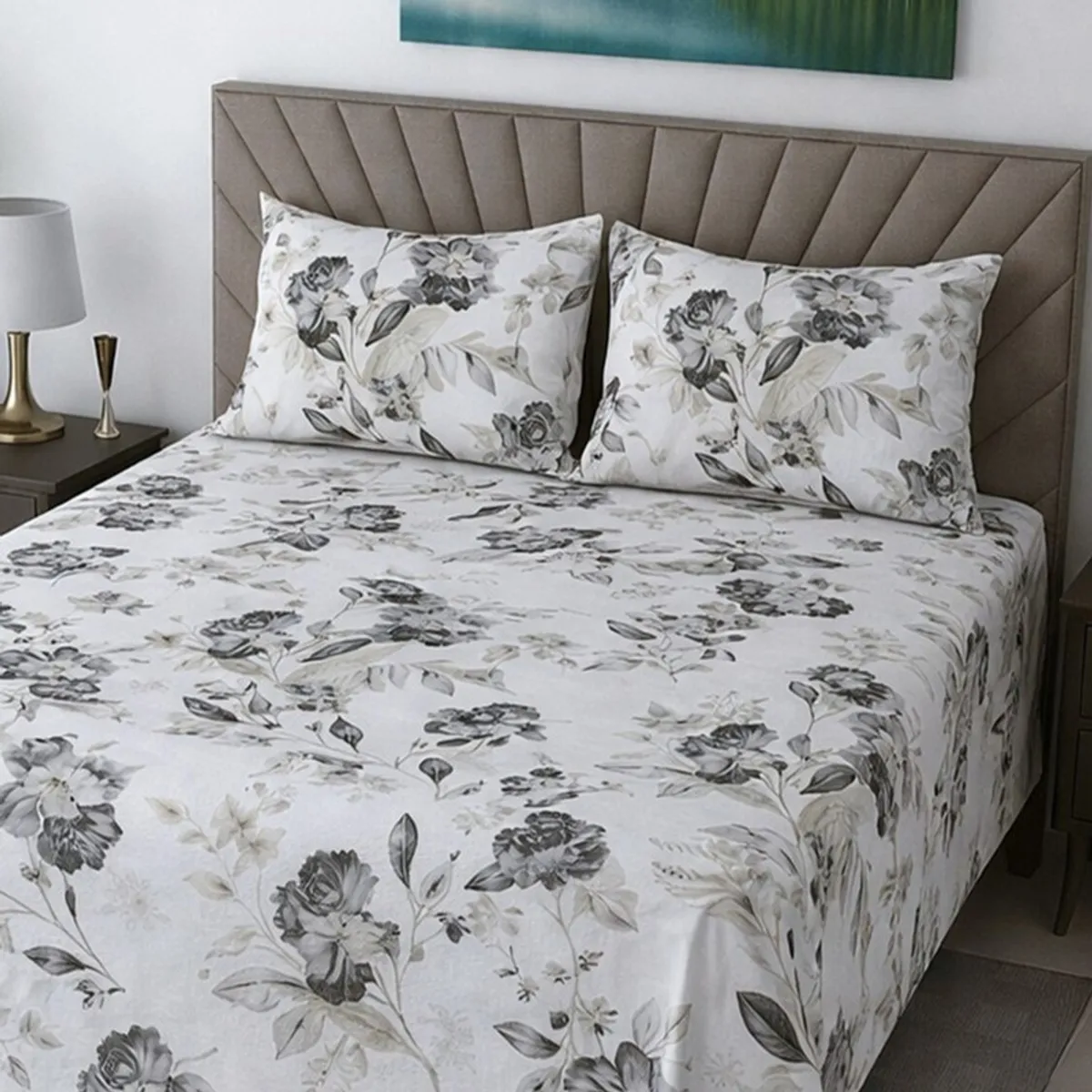 Close view of white floral bedsheet and matching pillow covers on a bed