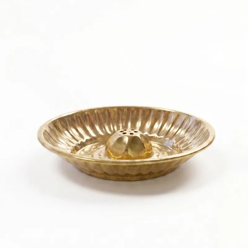 Side view of a round brass incense holder with raised centre
