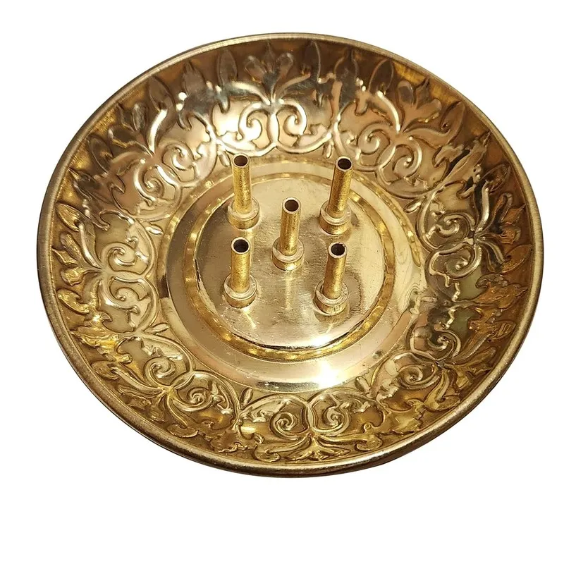 Top view of a round brass incense holder with an ornate floral rim and five holders