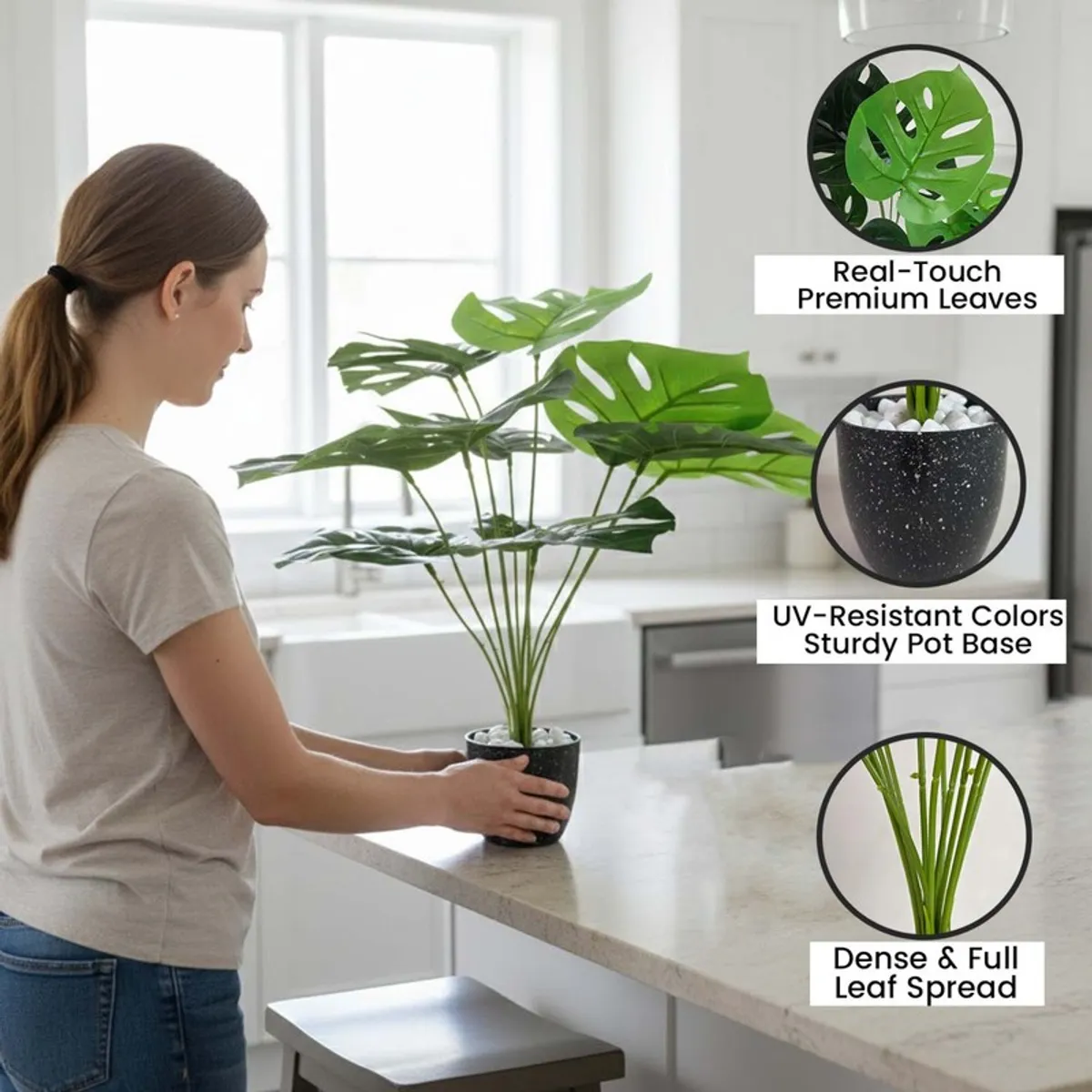 Close view of an artificial Monstera plant with green patterned leaves in a black pot.