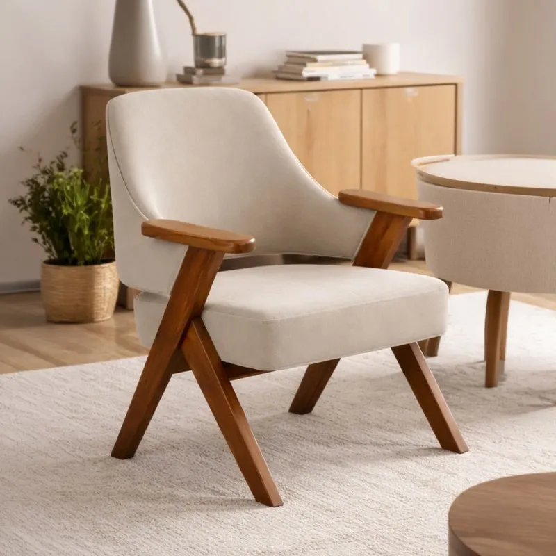 Beige upholstered accent chair with teak arms beside a cabinet