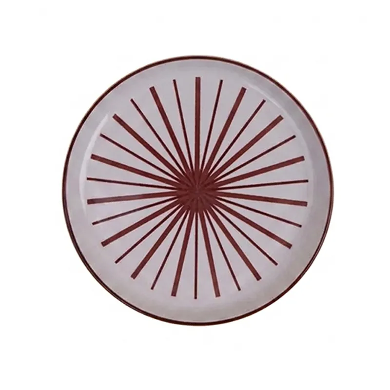 Top view of white round plate with maroon starburst pattern