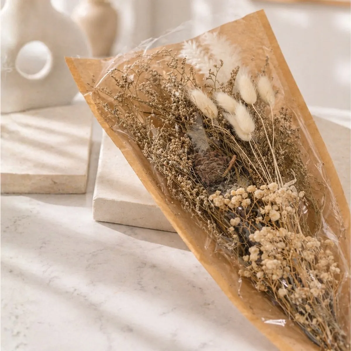 Wrapped dried flower bouquet with natural beige and cream botanical elements