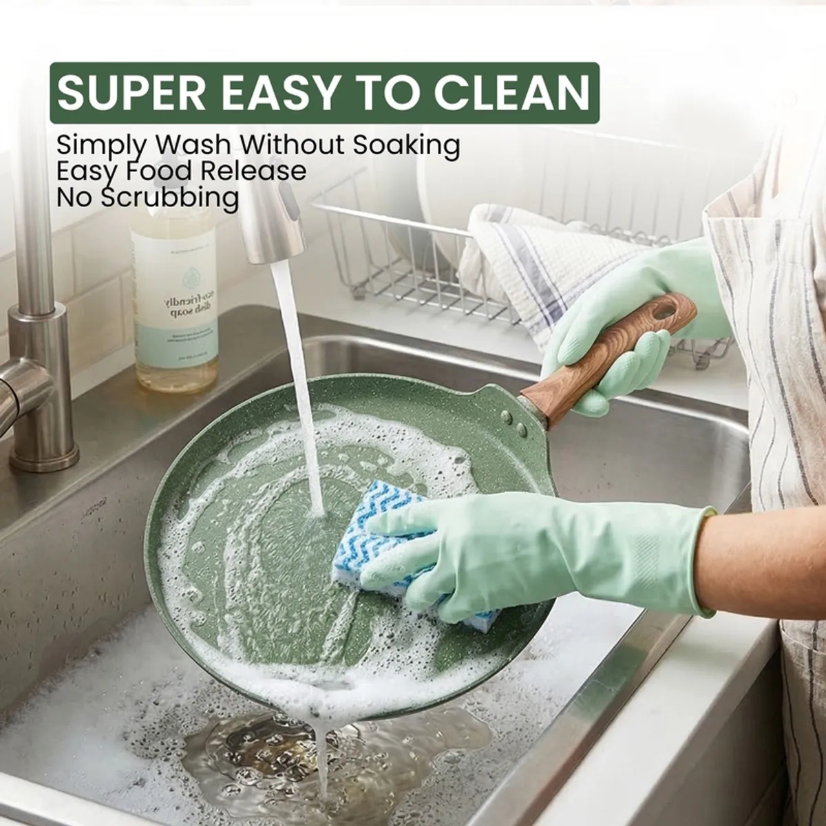 Moss green dosa tawa being washed under running water in a sink