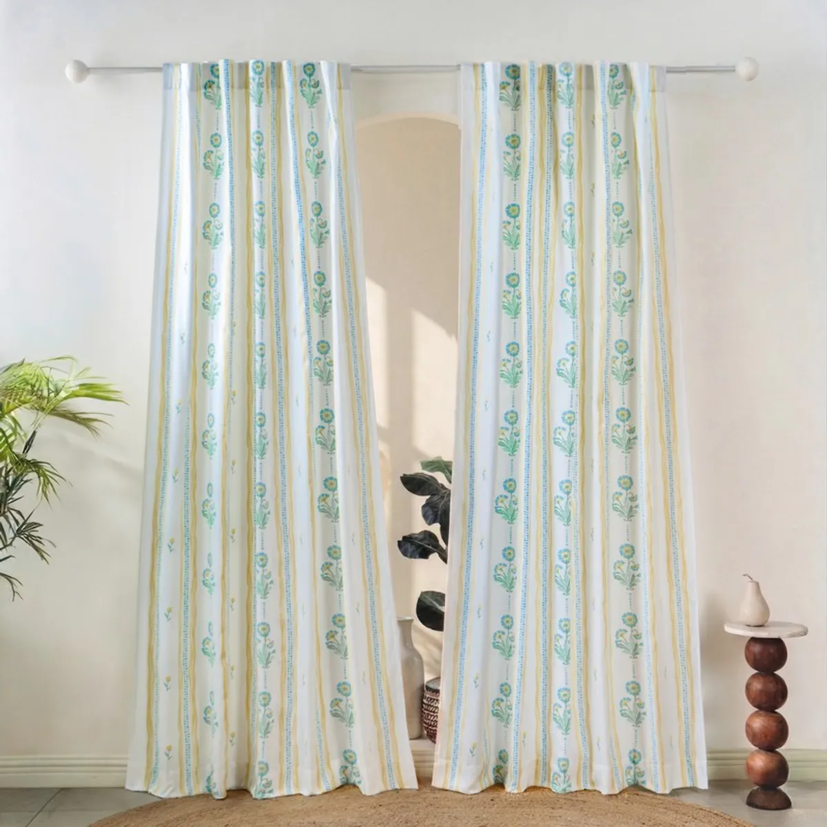 Pair of blue and yellow floral striped curtains hanging on a rod