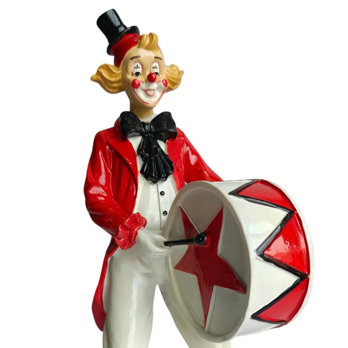 Close-up of clown figurine face, bow tie and star-detailed drum