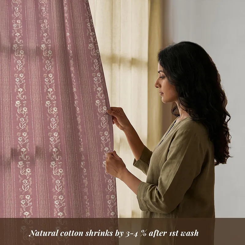Close view of pink floral cotton curtain beside an off-white panel