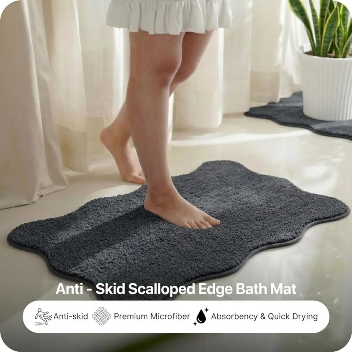 Person stepping onto a charcoal grey bath mat in a bright bathroom