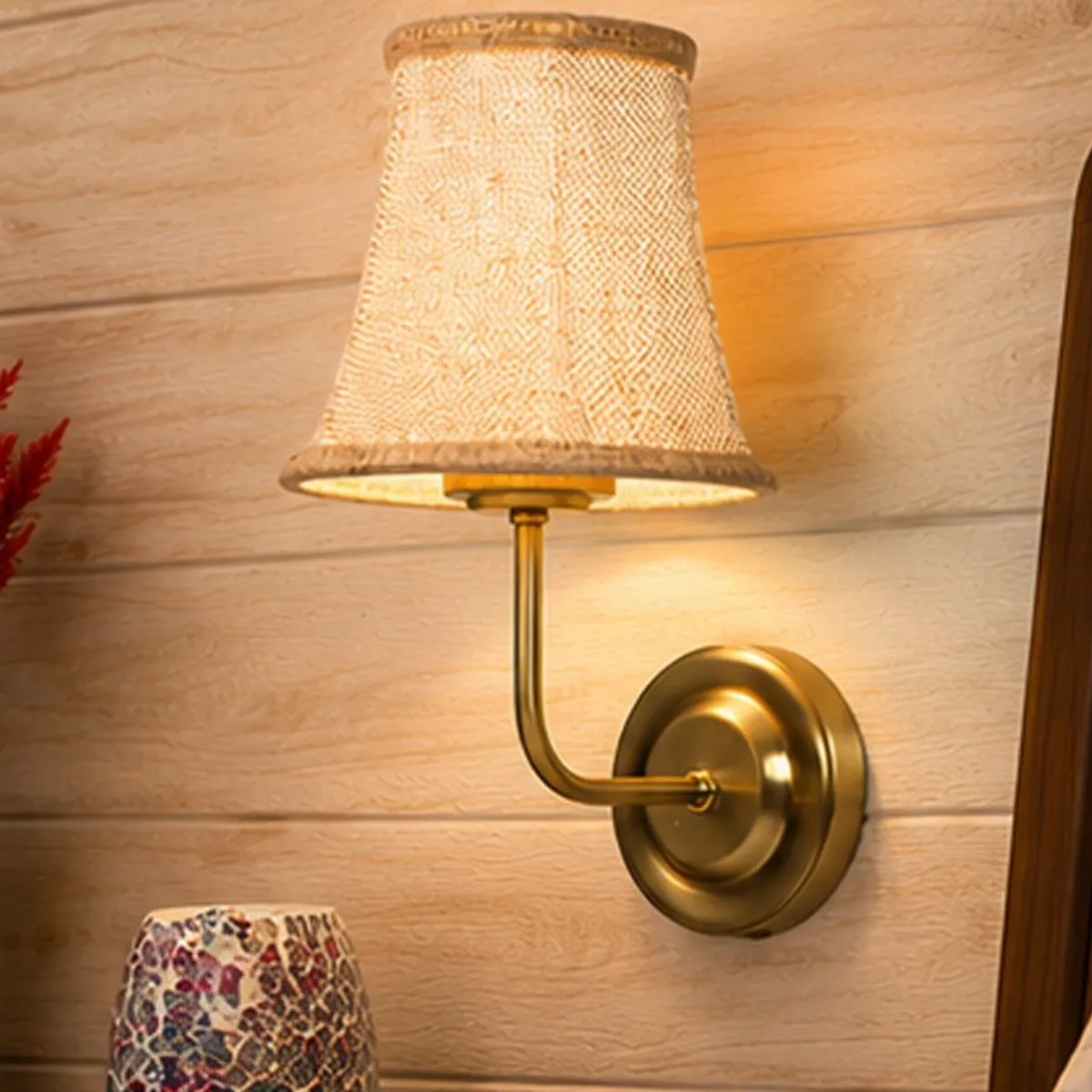 Close view of the beige jute shade and curved gold-toned metal arm
