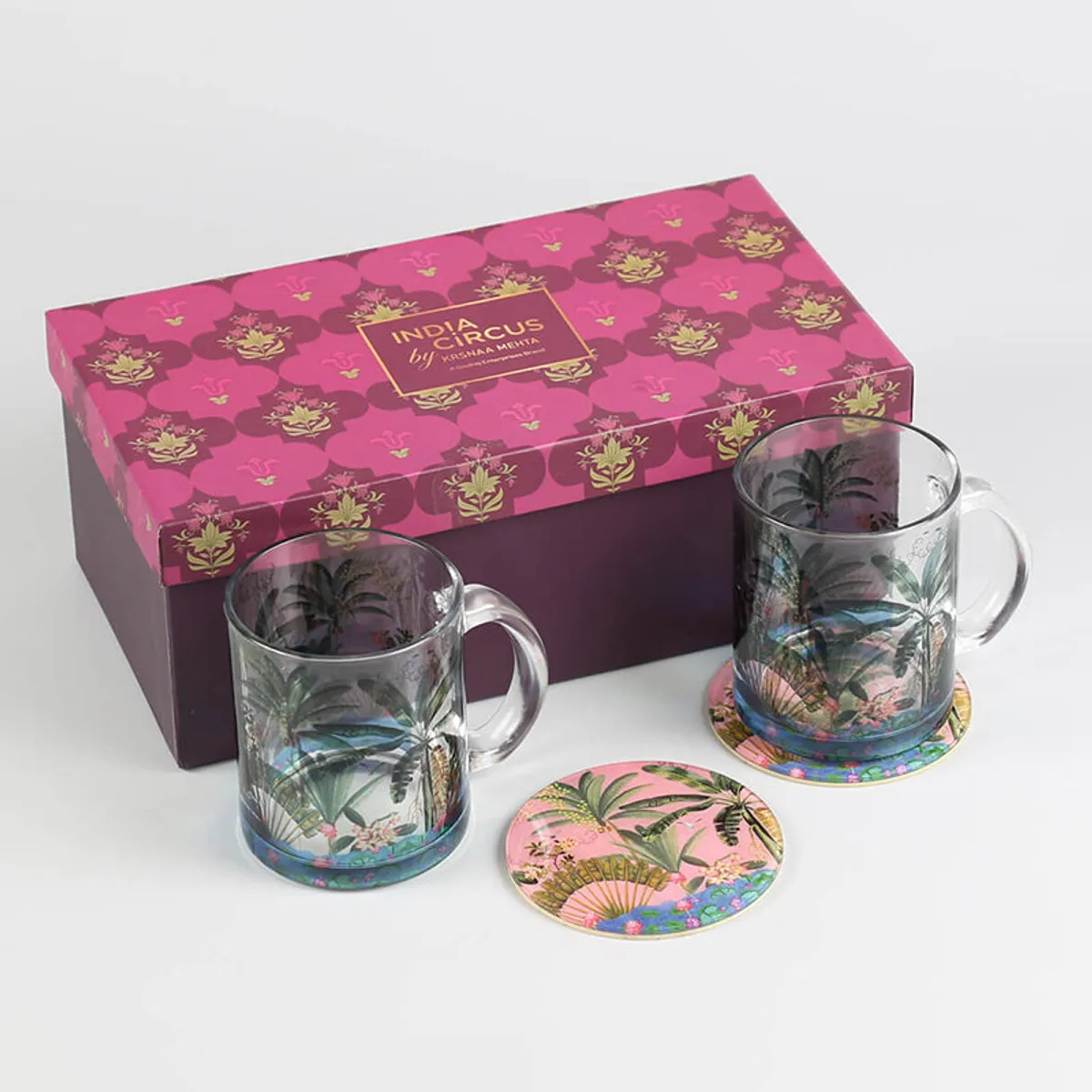 Two tropical glass mugs and coasters displayed with a decorative gift box