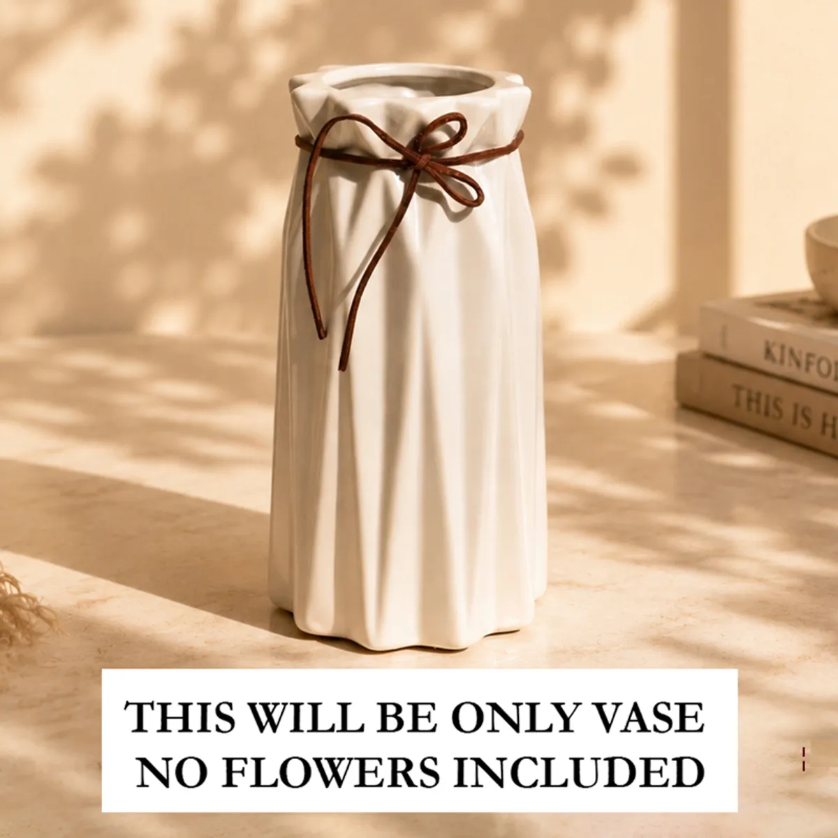 Empty white pleated vase with a brown bow on a sunlit tabletop