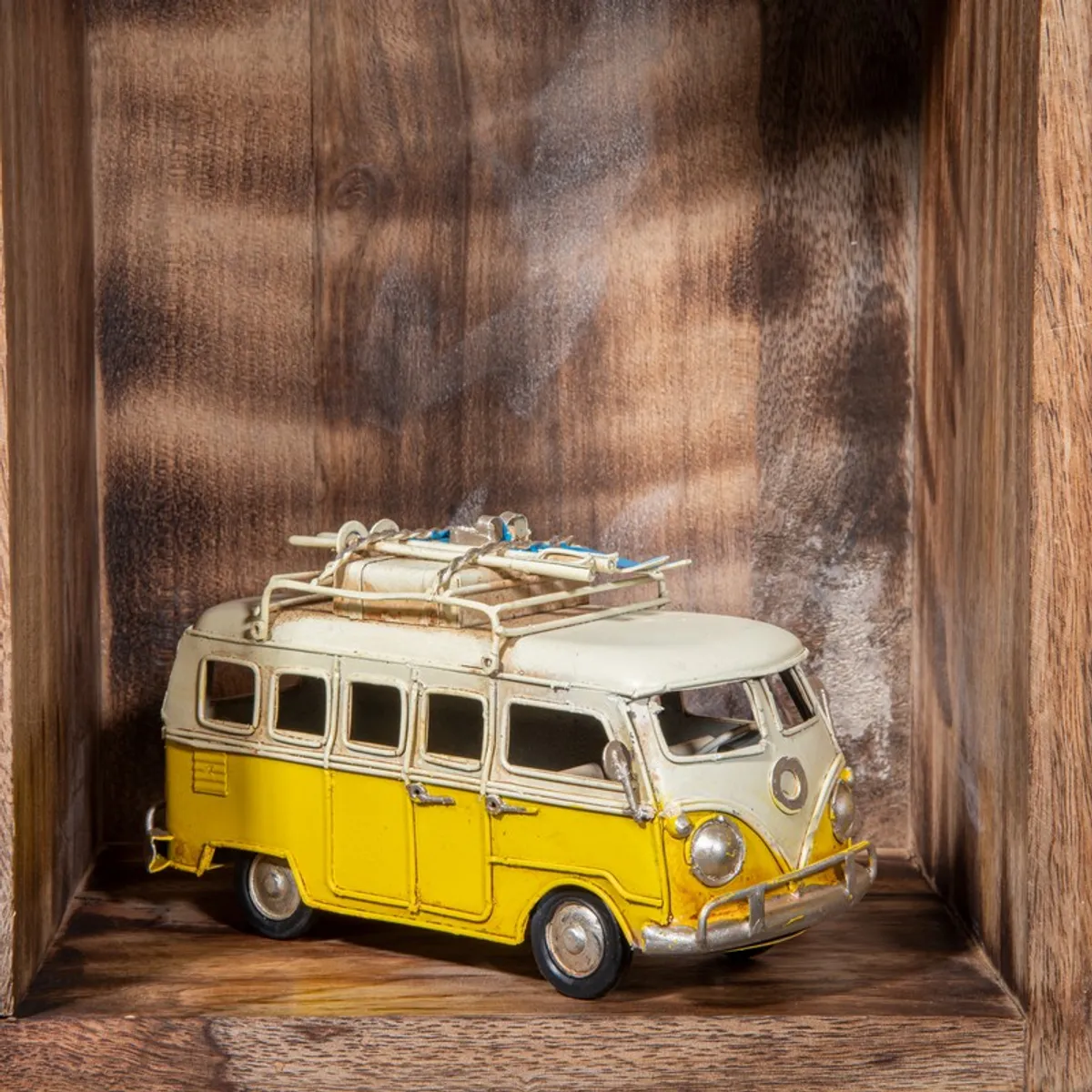 Side view of vintage yellow bus showpiece on a wooden shelf