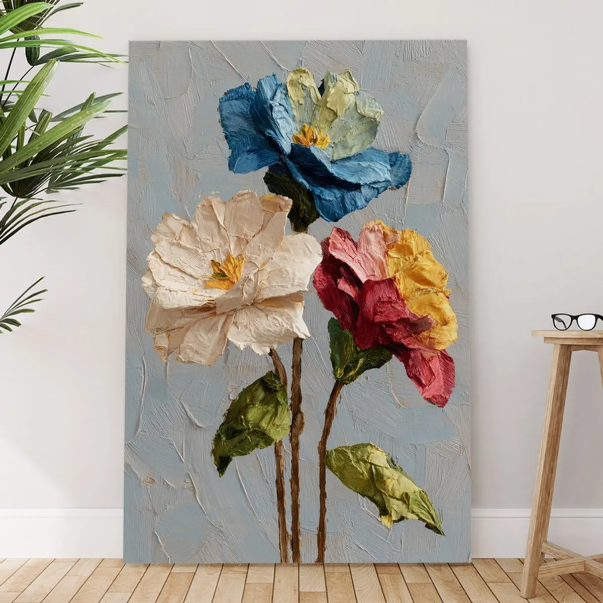 Textured floral wall painting leaning against a wall beside a stool
