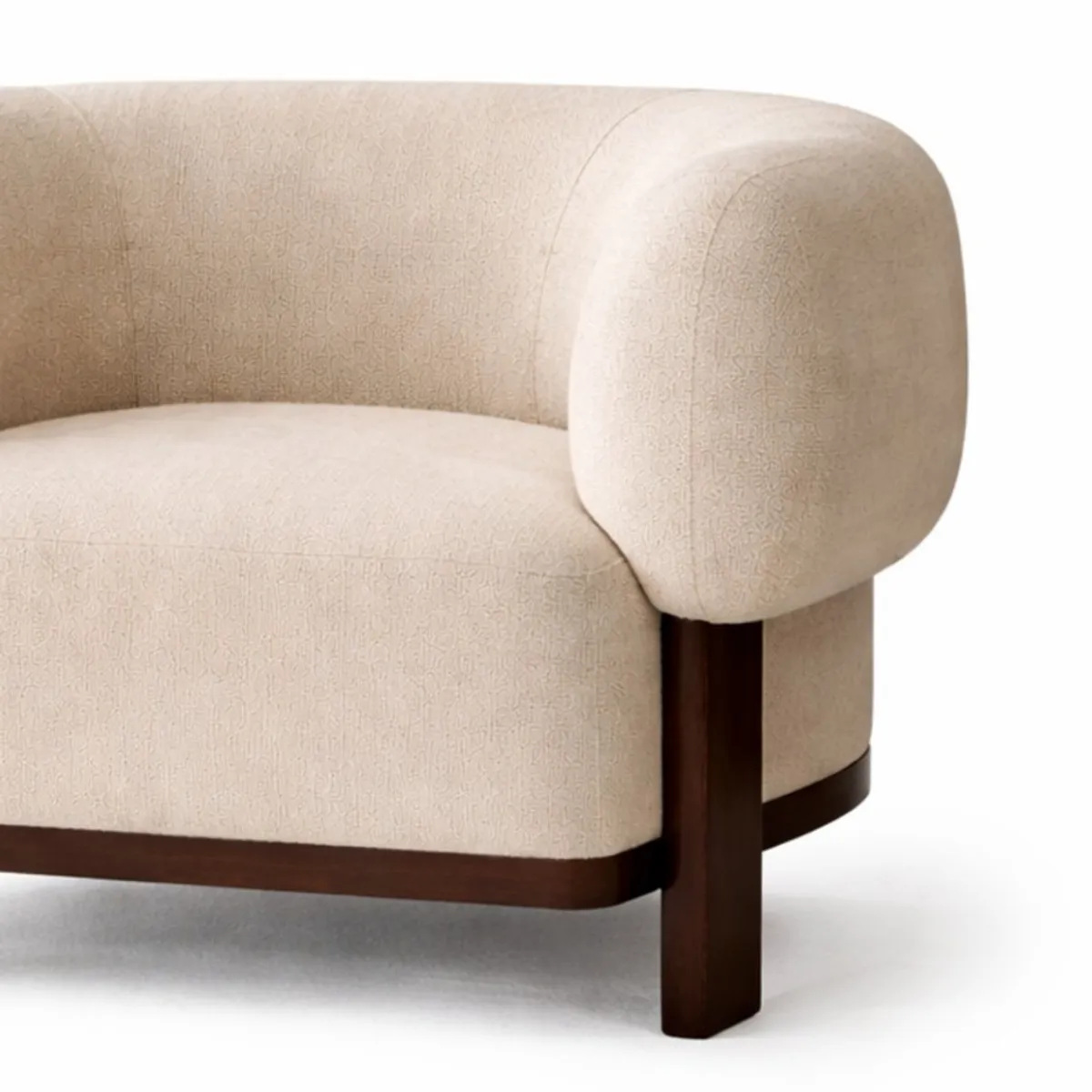 Close-up of beige textured upholstery, rounded arm and dark teak wood leg