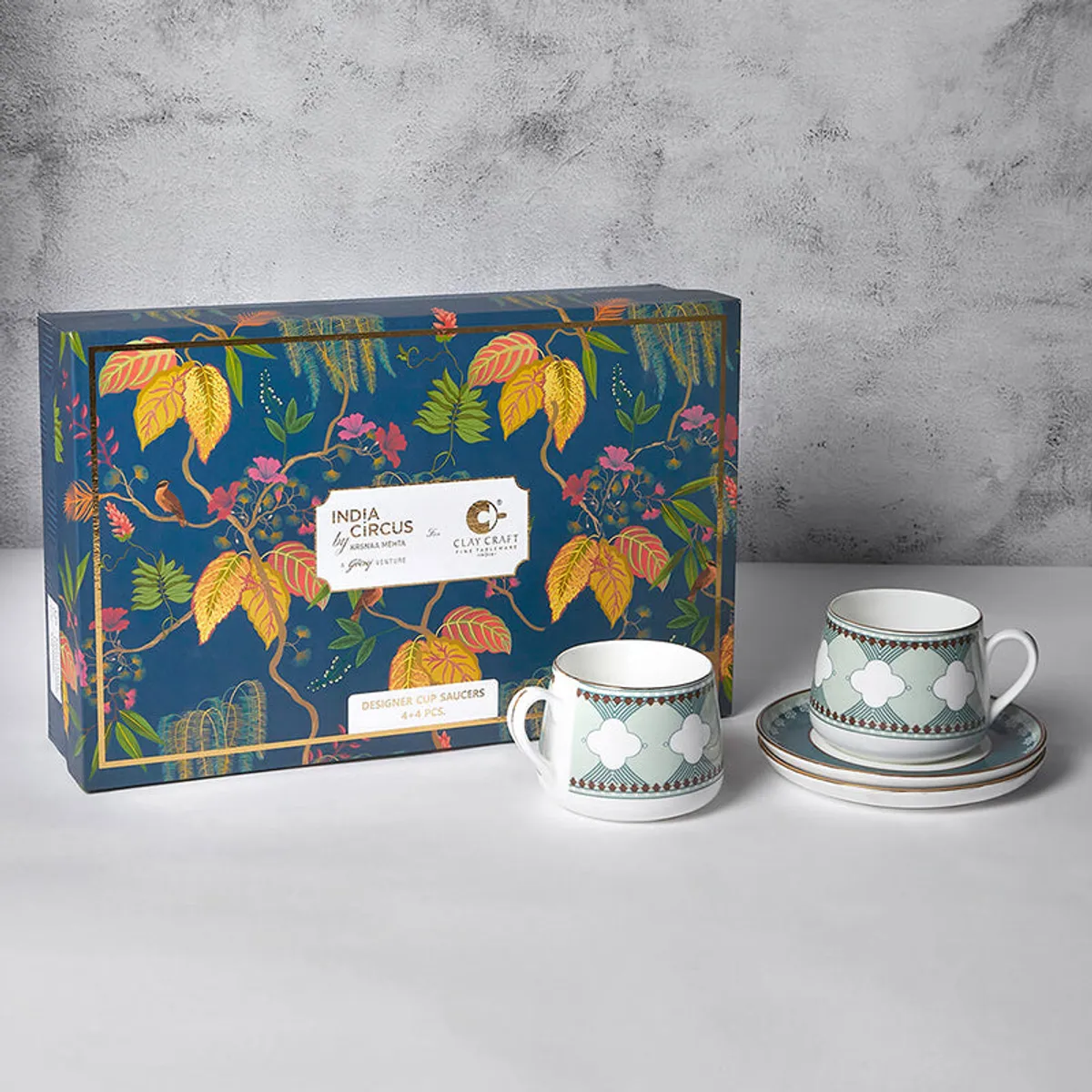 Eight-piece cup and saucer set shown beside its colourful gift box