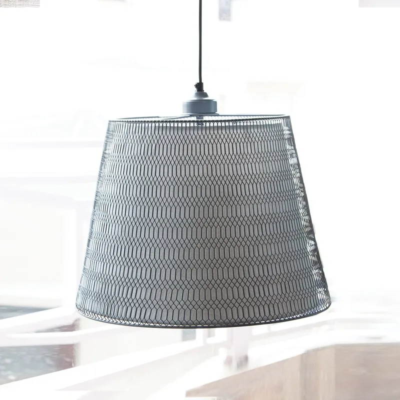 Grey hanging lamp with mesh shade suspended in a bright room