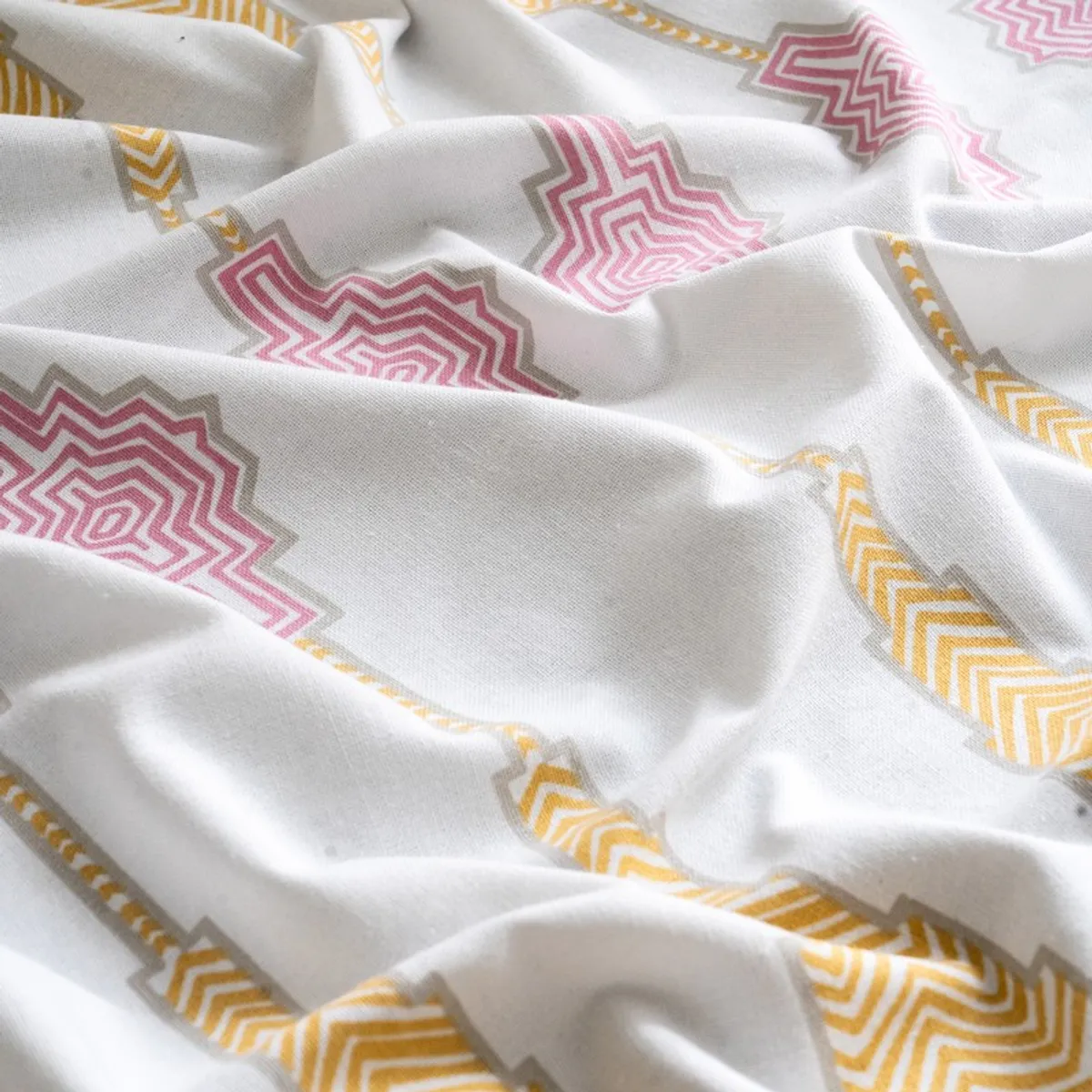 Close-up of soft white curtain fabric with pink and yellow motifs
