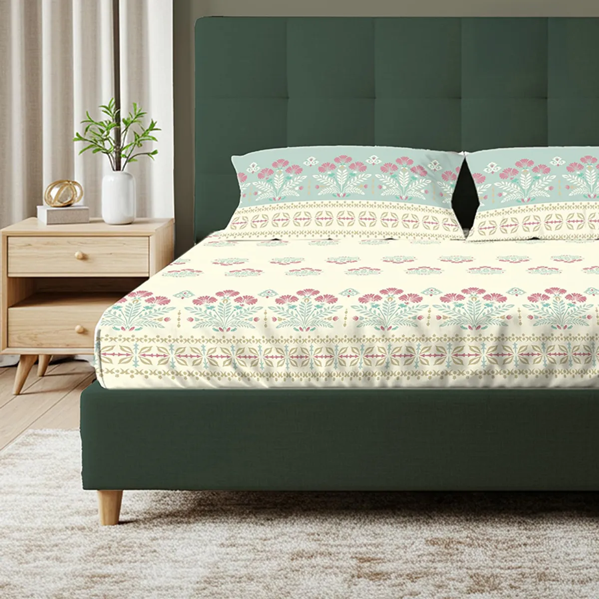 Front angled view of floral bedsheet with decorative border on a green bed