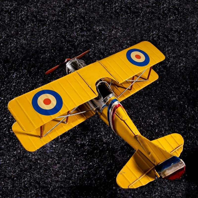 Top view of a yellow vintage biplane showpiece with round wingel markings