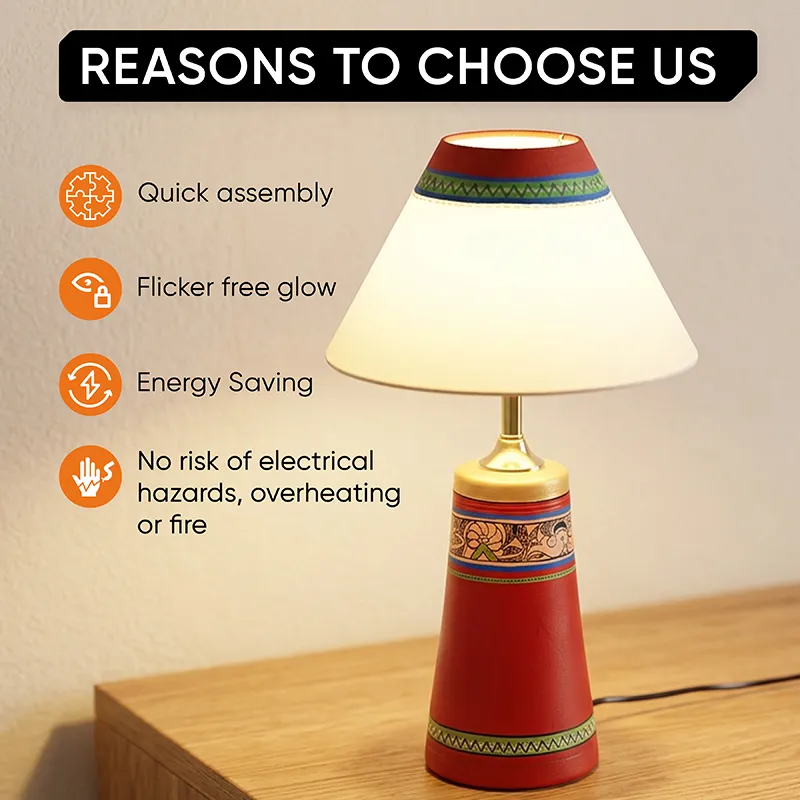 Lit red terracotta table lamp with cream shade on a wooden table