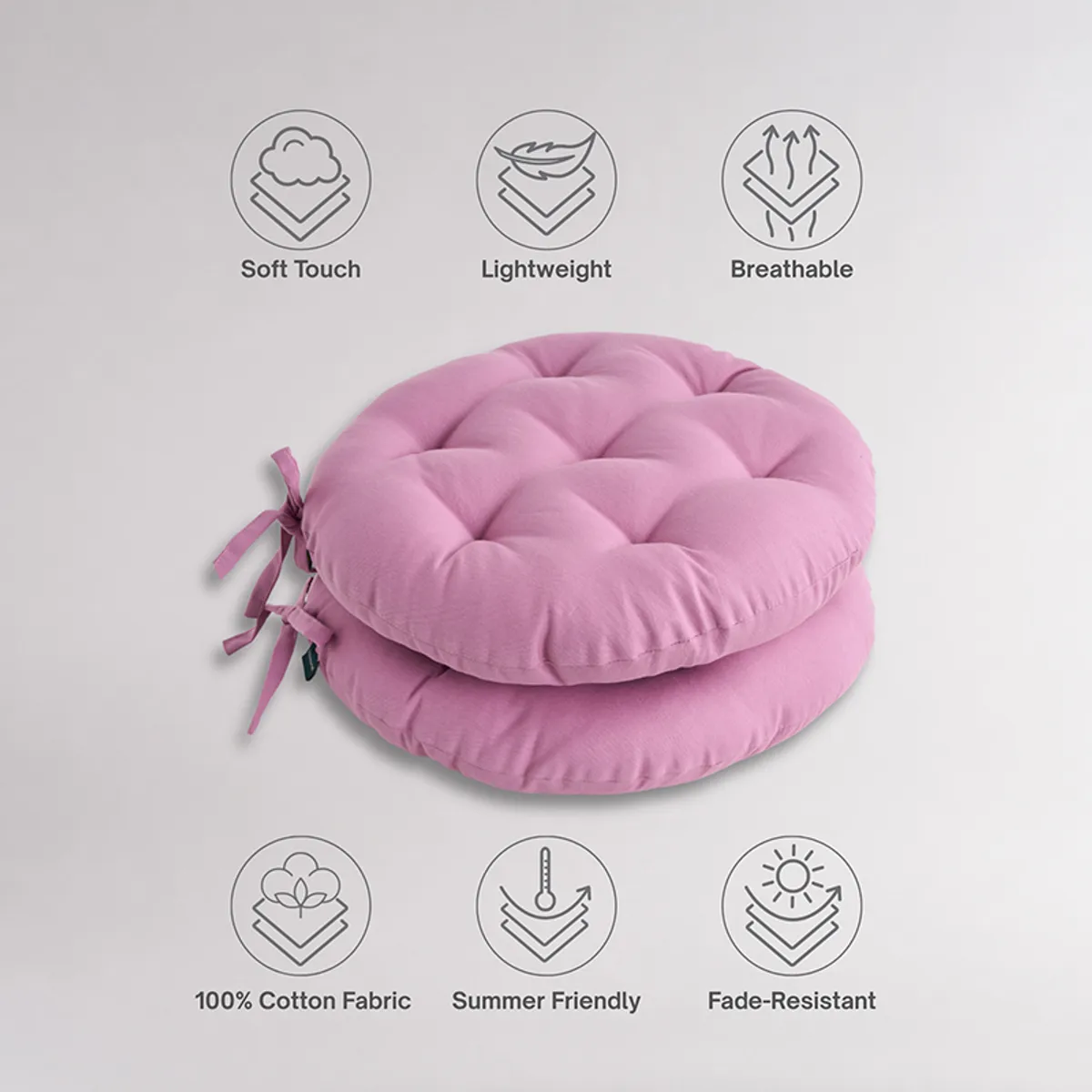 Two stacked lilac round chair pads with tufted surface and tie-ups