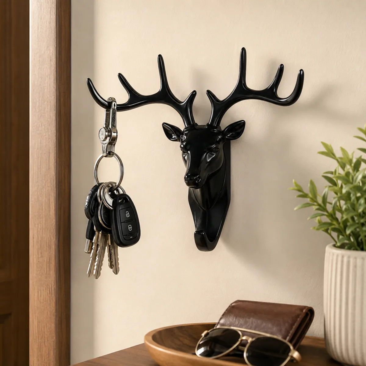 Black deer antler wall hook holding keys above a wooden shelf