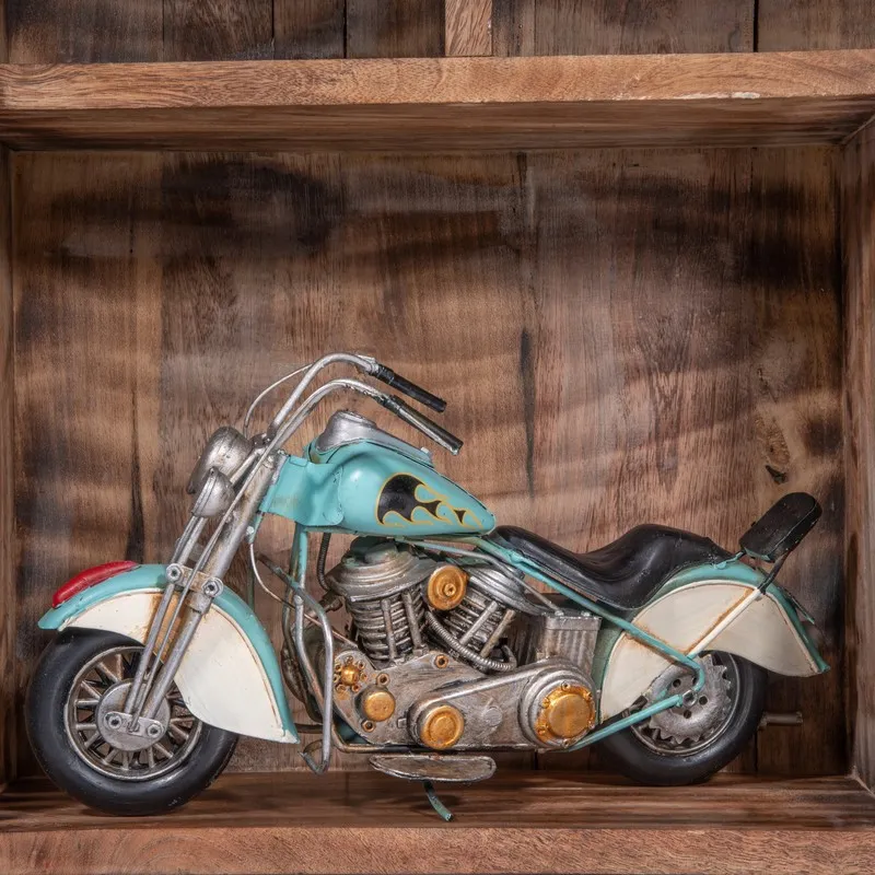 Side view of a blue vintage motorcycle showpiece on a wooden shelf