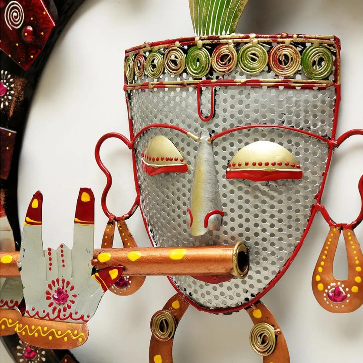 Close-up of the central metal face and decorative details on the wall accent