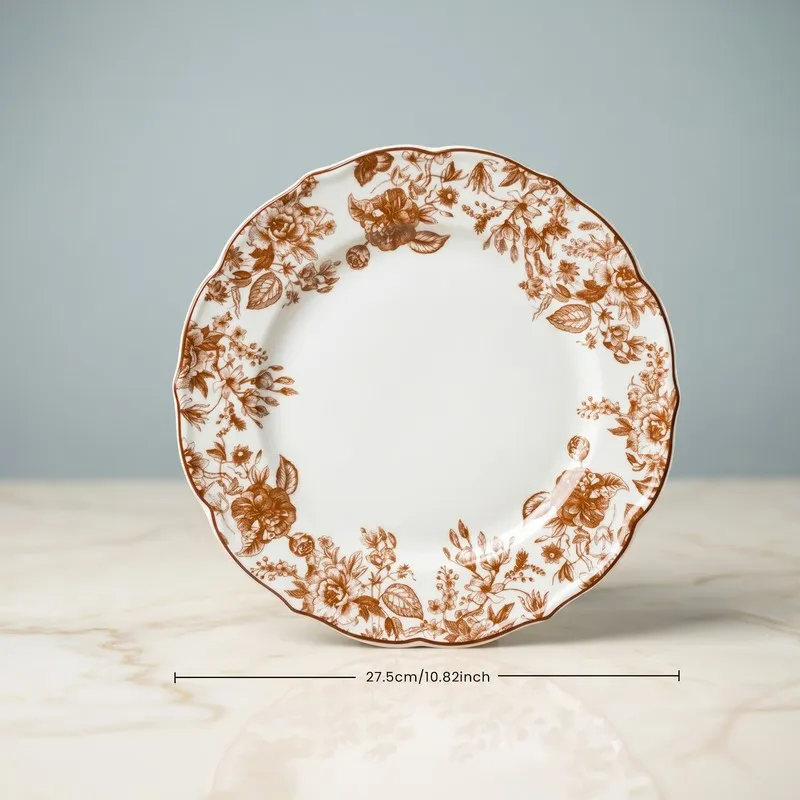 Single red and white floral dinner plate on a light surface