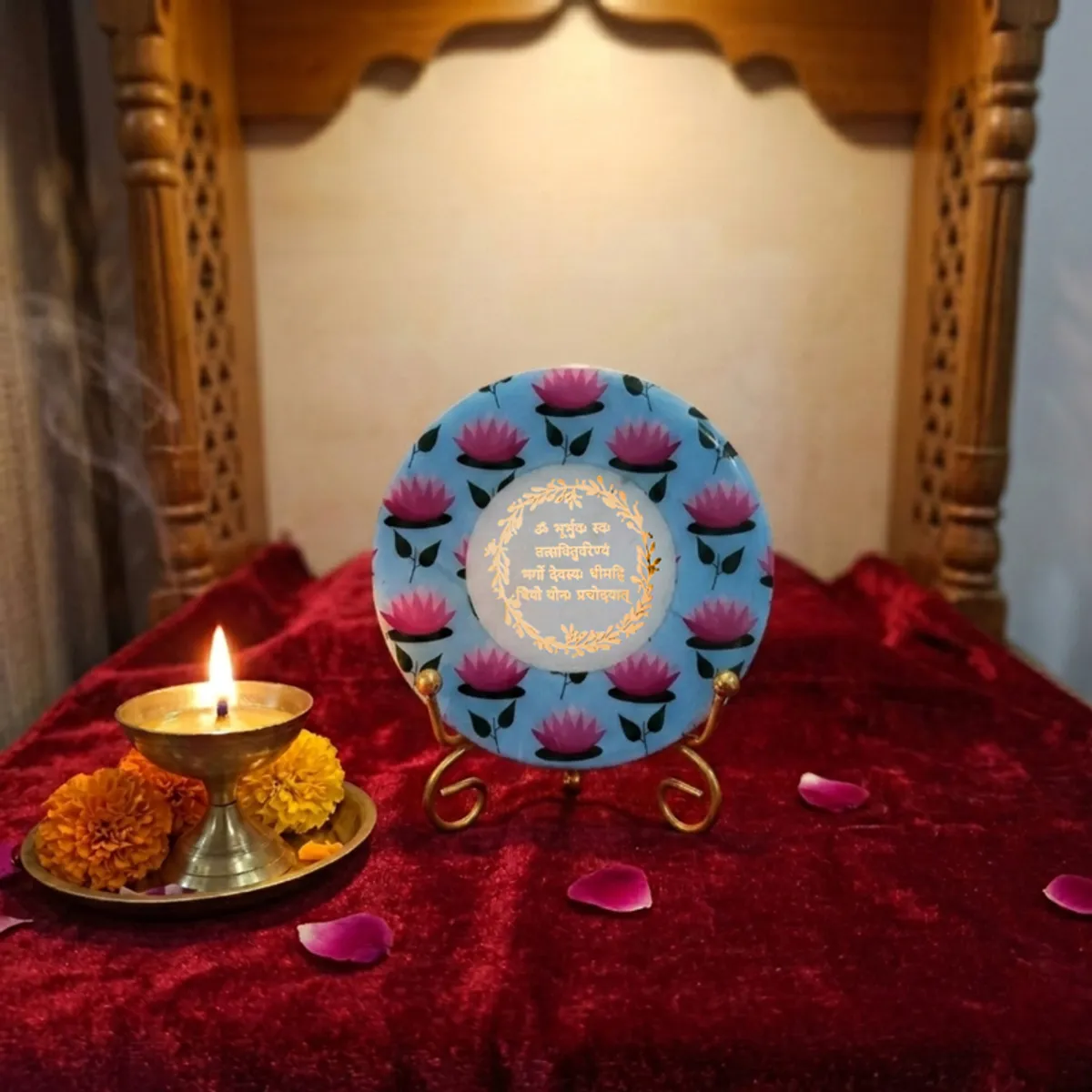 Lotus motif marble showpiece on a gold stand styled with a diya and petals