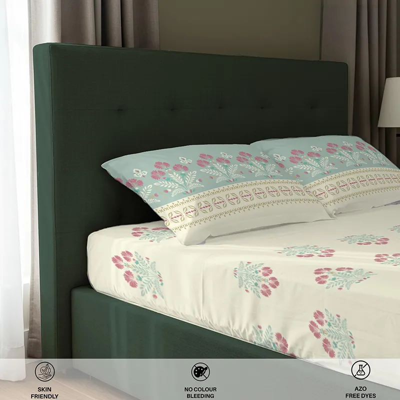 Side view close-up of fitted bedsheet and printed pillow covers on a bed