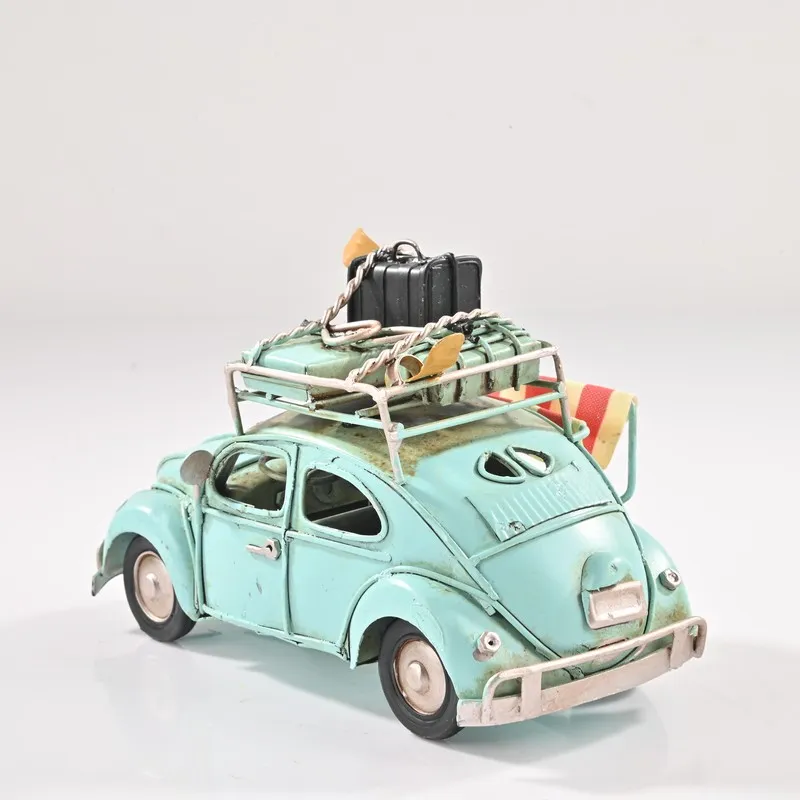 Rear angled view of blue vintage beetle car showpiece with rooftop luggage