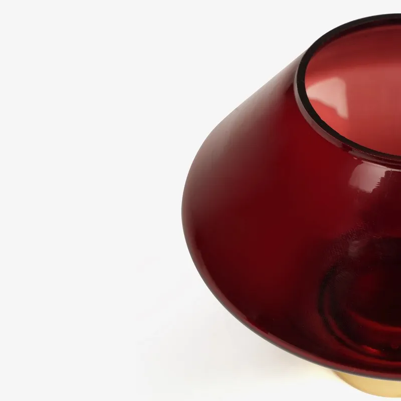 Close-up of ruby red glass candle holder with gold base