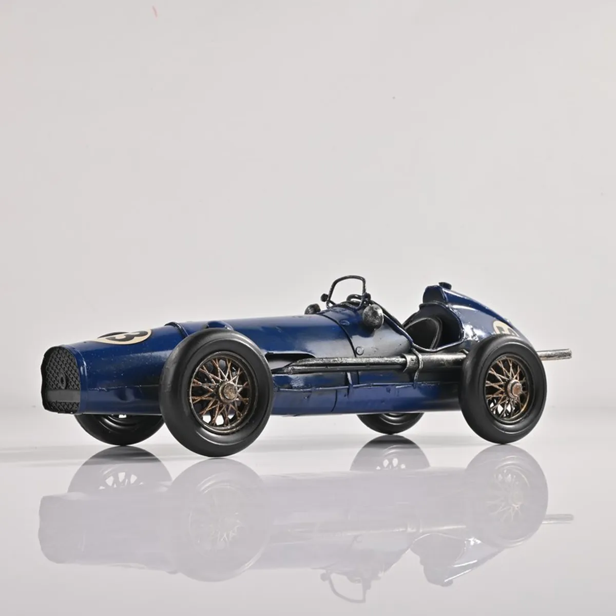Side view of blue vintage racing car showpiece on a white background
