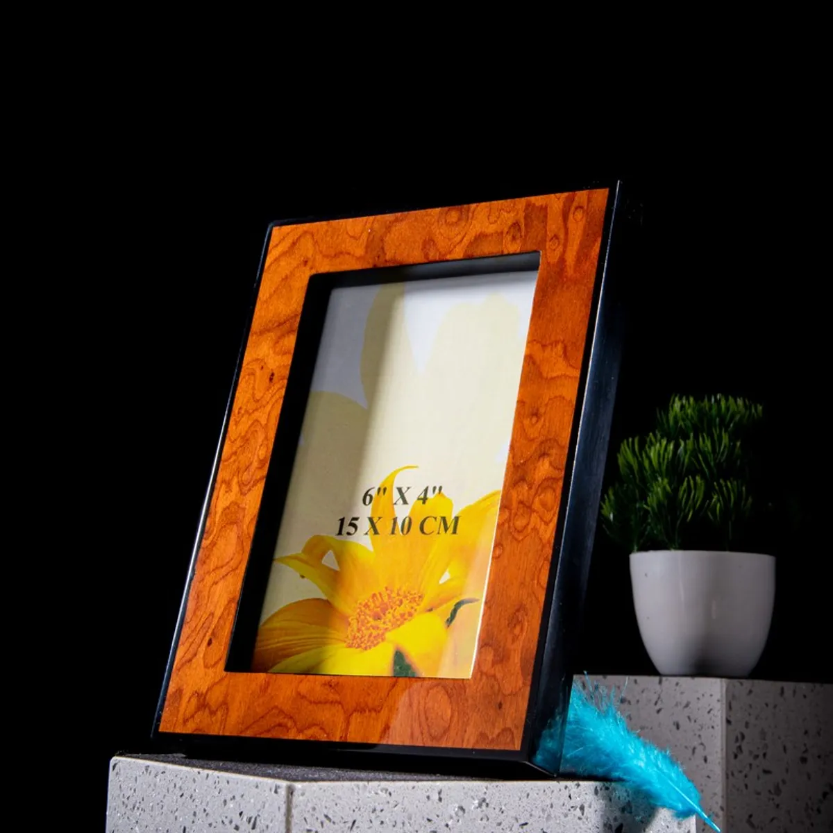 Angled tabletop view of a brown wood-look photo frame with black sides