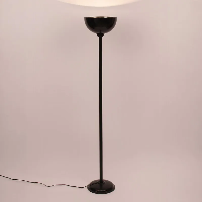 Black floor lamp with lit uplight bowl against a soft backdrop