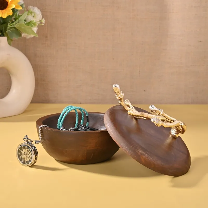 Open brown accent bowl with lid beside jewellery and a watch