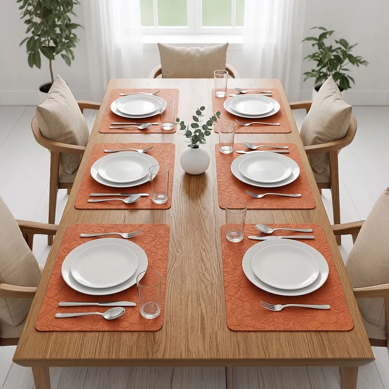 Dining table set with six orange rectangular table mats and white plates